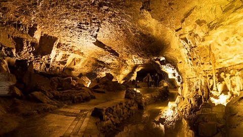 Daoine a' coiseachd tro Uamh Dan-yr-Ogof