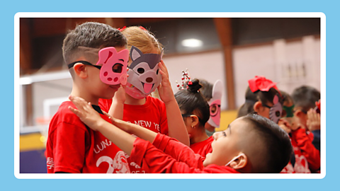 A group of children wearing different masks made of foam. The masks represent different animals such as a pig and a dog.