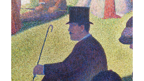 A close-up of the same painting. There are lots of dots which make up the image of a person wearing a top hat and holding a stick while sitting on green grass.