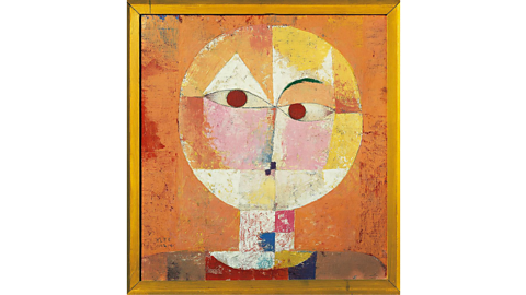A mainly orange cubist portrait, which features a face made of mismatched shapes in the colours pink, yellow, white and red.