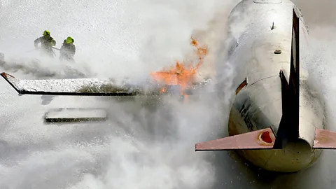 Firefighters spray foam on an aircraft during a drill (Credit: Mehmet Kaman/Getty Images)