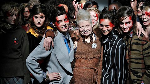 Vivienne Westwood with her arms around the models surrounding her, who are wearing her punk designs.