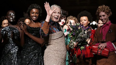 Vivienne Westwood waving with lots of models behind her.