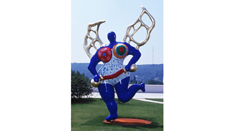 A Nana by Niki de Saint Phalle, with silver wings and a bright blue body.