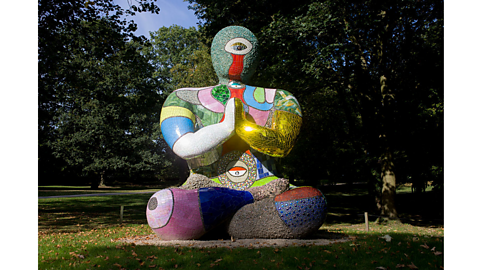 A Nana by Niki de Saint Phalle, painted with multiple different colours and materials.