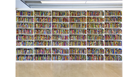 The British Library installation, consisting of a wall of shelves filled with books covered in colourful patterned fabric.