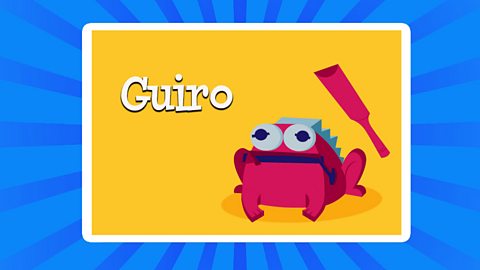 A cartoon of a Guiro in the shape of a frog with the text above saying "Guiro"