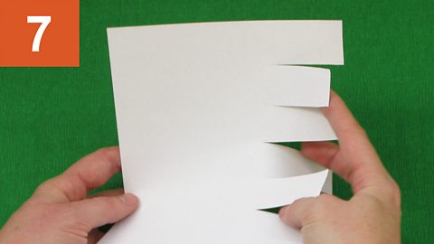 Strip fringe - step 7. Hands ruffle fringed piece of paper