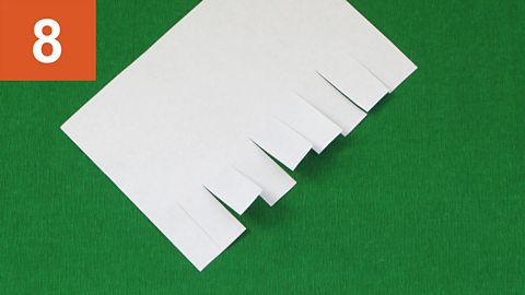 Strip fringe - step 8. Piece of paper with fringing along one side of it