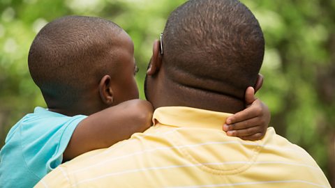 A young boy and his father hug each other