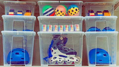 Plastic boxes with childrens toys rollers and a helmet