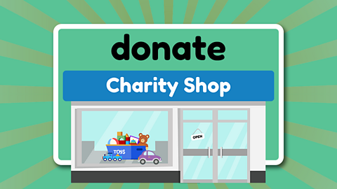 A charity shop front with an open sign on the door. In the window there is a box of toys and a toy car and train at the front of the box.