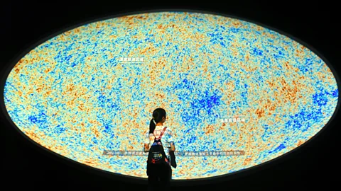 A girl looking at an image of the cosmic microwave background (Credit: Getty Images)