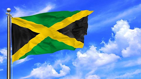 The Jamaican flag flying against a blue sky.