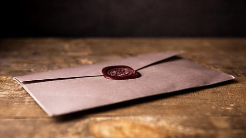 A vintage letter sealed with wax lying on a table.