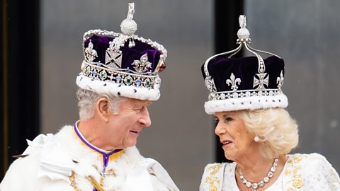 King Charles III and Queen Camilla look at each other while wearing crowns (Credit: Getty Images)