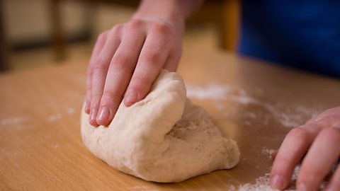 A child's hands folding the dough in half