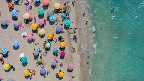 Aerial view of umbrellas on beach near shoreline (Credit: Getty Images)