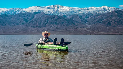 Man laying back in kayak on lake