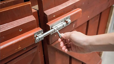 A wooden gate with a sliding bar latch.