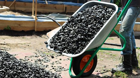 A wheelbarrow full of stones. Tipped up on the front wheel which acts as a fulcrum.