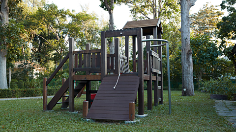 A wooden climbing frame in a park