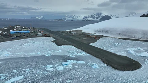 Workers stand in front of earth moving machinery on a runway at Rothera Research Station in Antarctica (Credit: BAM)