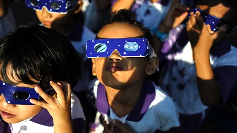 Child watches eclipse with protective eyewear