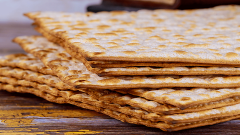 Seven pieces of Matzah bread on a wooden counter