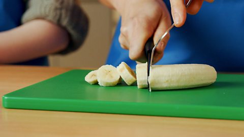 A child slice more pieces of banana