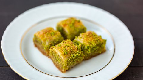 Four pieces of baklava on a white plate