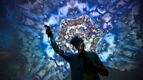 Man wearing virtual reality headset amidst tessellated blue projection (Credit: Getty Images)