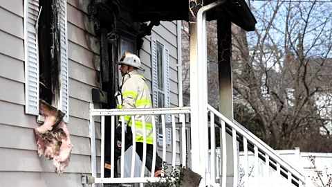 Firefighter walking into burned house (Credit: Getty Images)