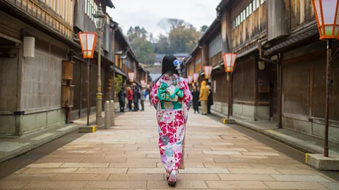 Woman in kimono walking in traditional area of Kanazawa