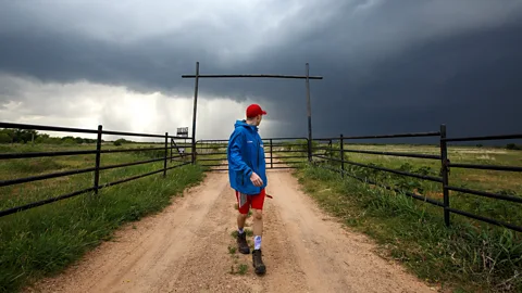 Man looking back at tornado forming (Credit: Getty Images)
