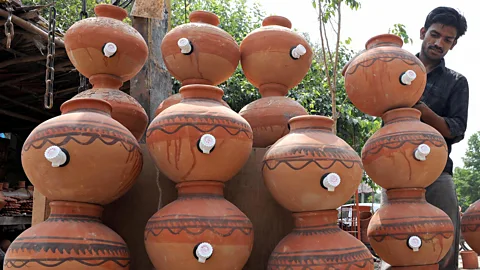 Man standing with terracotta pots (Credit: Getty Images)