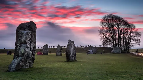 Avebury henge with people in background celebrating the solstice (Credit: Alamy)