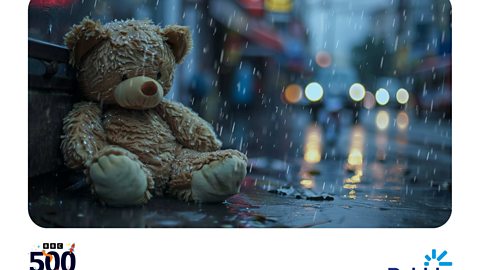 A Teddy bear sits alone on a rainy street.