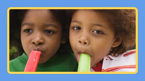 Two boys eating iced lollies.
