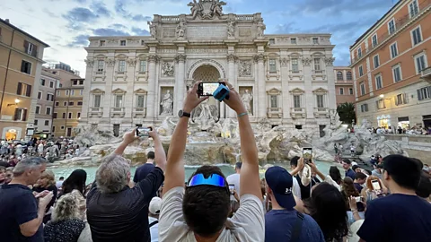 Tourists taking photos at the Trevi Fountain in Rome (Credit: Kathleen Rellihan)