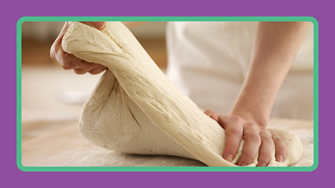 A person kneading bread dough.