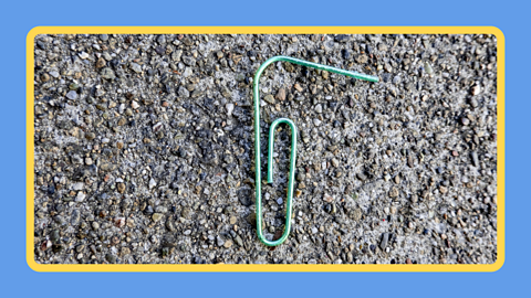 Paper clip on a concrete floor.