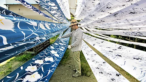 A man looking at recycled garments (Credit: Getty Images)