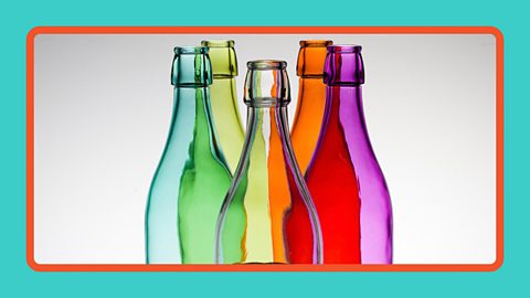 Five brightly coloured glass bottles lit up from beneath.