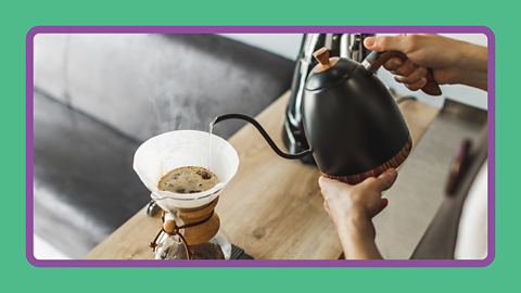 Hot water being poured through filter paper making coffee.