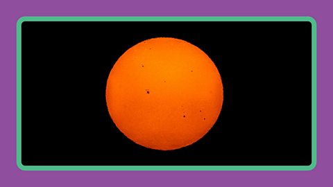 The Sun seen through a dark lensed telescope with sun spots.