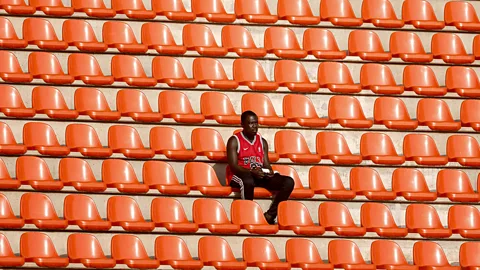 Two people sit in deck chairs surrounded by water (Credit: Getty Images)