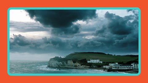 Dark clouds over a coastal town and the sea in Cornwall, UK.