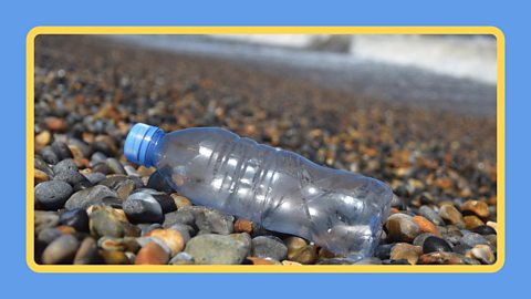 Discarded plastic bottle washed up on pebble beach