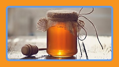 A jar of honey sealed on a work top.